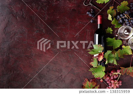 Red Wine Bottle with Grapes and Vine Leaves on Rustic Background 138315959