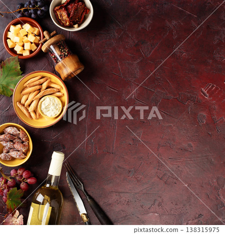 Charcuterie Snacks and White Wine on Dark Rustic Background Charcuterie Snacks and White Wine on Dark Rustic Background 138315975