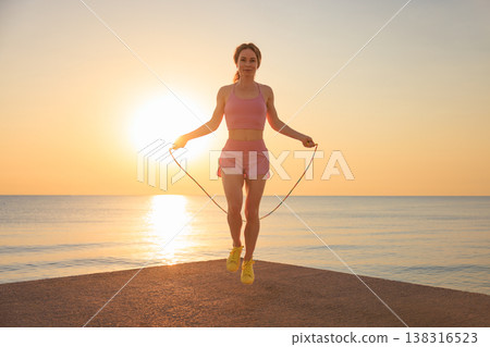 Fit woman jumping rope at the beach during summer vacation 138316523
