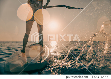 Young woman walking on sup board by the sea during summer vacation 138316533