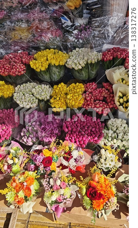 A vibrant display of flower bouquets featuring roses, tulips, and mixed arrangements, arranged neatly at a market stall with clear visibility of colors A vibrant display of flower bouquets featuring roses, tulips, and mixed arrangements, arranged neatly at a market stall with clear visibility of colors 138317276