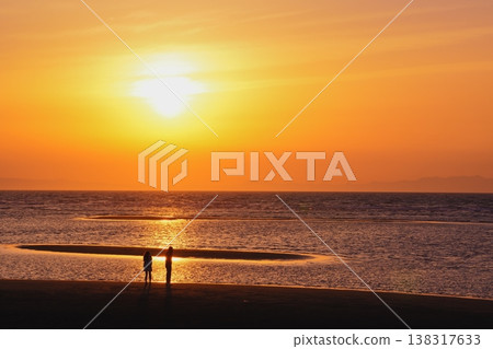 馬塔馬海灘的日落,以及站在潮灘上的兩個人的剪影。 馬塔馬海灘的日落,以及站在潮灘上的兩個人的剪影。 138317633