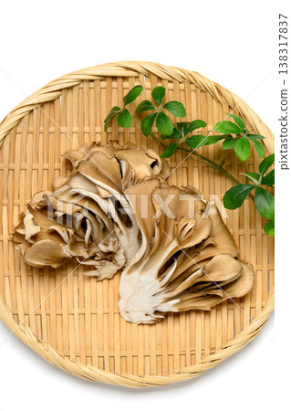 Maitake mushrooms placed on a bamboo basket against a white background. Maitake mushrooms placed on a bamboo basket against a white background. 138317837
