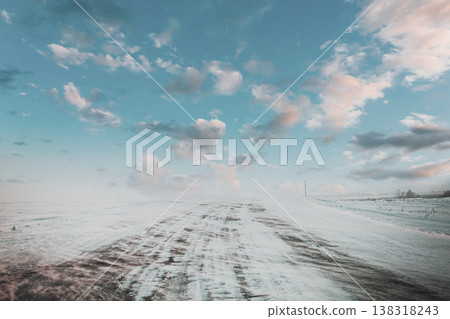 Snowdrift sweeping across a rural road under a bright winter sky Snowdrift sweeping across a rural road under a bright winter sky 138318243