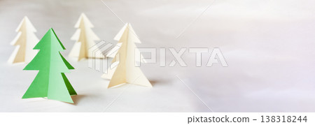 Paper origami Christmas trees in green and white on a light background 138318244