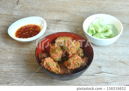 fried grouper fish patty with slice cucumber on bowl dipping sweet chili sauce 138319852