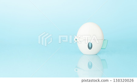 Asthma and COPD concept. Tiotropium bromide inhaler with reflection on light blue background. Pharmaceutical device of bronchodilator for lung inflammation treatment and prevent asthma attack. 138320026