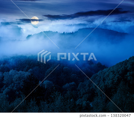 mountain landscape with cold fog at night. low clouds evaporating over the forested hill in full moon light. outdoor scenery in spring for remote highland ecotourism. mysterious greenery fantasy mountain landscape with cold fog at night. low clouds evaporating over the forested hill in full moon light. outdoor scenery in spring for remote highland ecotourism. mysterious greenery fantasy 138320047