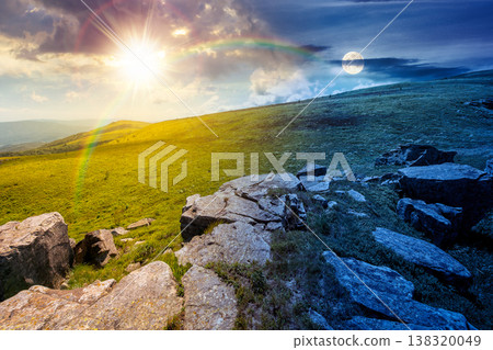 mountainous landscape during summer solstice. day meet night. sun and moon over boulders and rock formations surrounded grassy hills. picture of an untouched highland. equality and shift template mountainous landscape during summer solstice. day meet night. sun and moon over boulders and rock formations surrounded grassy hills. picture of an untouched highland. equality and shift template 138320049