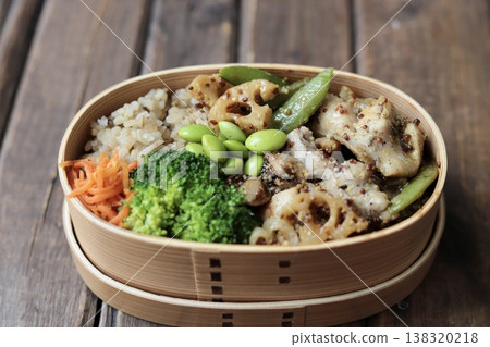 一份健康的便當盒，裡面有芥末雞肉和大量蔬菜，熱量低於500卡路里。 138320218