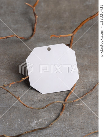 Blank gift tag mockup on grey stone with dry branches, copy space. Handmade product label 138320433
