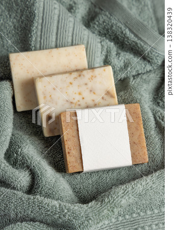 Handmade solid soap bars mockup with blank paper label on light green towel, unbranded packaging 138320439