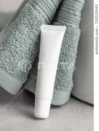 White blank eye cream tube mockup near light green bath towel. Cosmetic skincare product packaging White blank eye cream tube mockup near light green bath towel. Cosmetic skincare product packaging 138320443