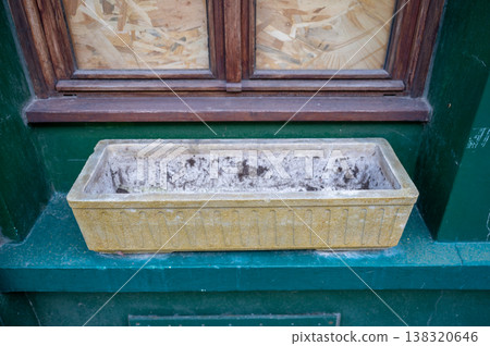 Old concrete window planter on green facade empty flower box with wooden frame window urban exterior detail Old concrete window planter on green facade empty flower box with wooden frame window urban exterior detail 138320646