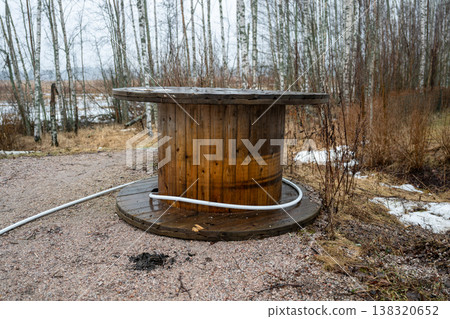 Wooden cable reel table in outdoor natural landscape rustic industrial object in forest environment Wooden cable reel table in outdoor natural landscape rustic industrial object in forest environment 138320652
