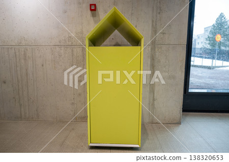 Modern yellow recycling bin in minimalist interior with concrete wall eco waste management concept Modern yellow recycling bin in minimalist interior with concrete wall eco waste management concept 138320653