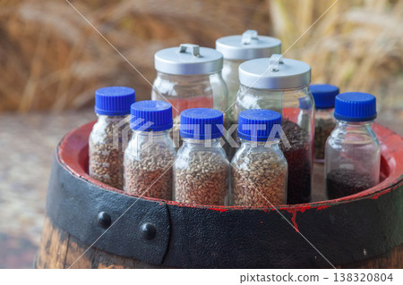 Beer ingredients in glass jars on wooden barrel 138320804