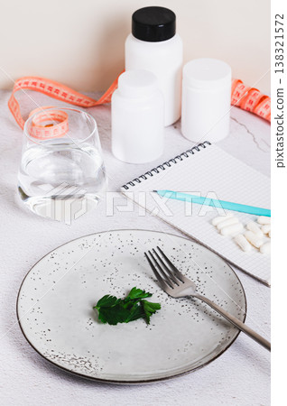 Concept of hunger, diet, weight loss and vegetarianism on an empty plate vertical view Concept of hunger, diet, weight loss and vegetarianism on an empty plate vertical view 138321572