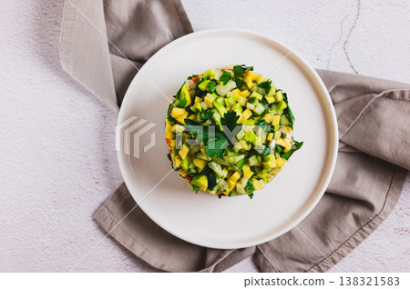Close up of diet salad with avocado, cucumber and red fish on a plate on the table top view Close up of diet salad with avocado, cucumber and red fish on a plate on the table top view 138321583