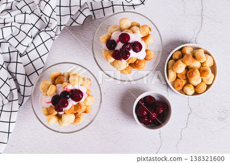 Small round cookies, yogurt and cherry jam in bowls on the table top view Small round cookies, yogurt and cherry jam in bowls on the table top view 138321600