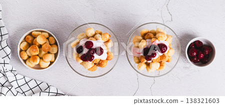 A delicious crunchy dessert with cookies, yogurt, and berries in bowls top view web banner 138321603