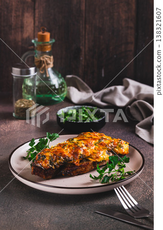Pork loin baked with cheese, tomatoes and mushrooms on a plate on the table vertical view Pork loin baked with cheese, tomatoes and mushrooms on a plate on the table vertical view 138321607
