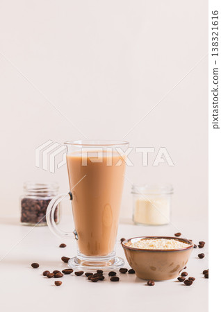 Protein coffee in a glass and protein powder in a bowl on the table vertical view Protein coffee in a glass and protein powder in a bowl on the table vertical view 138321616