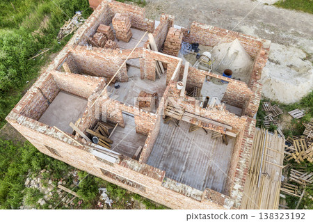 Aerial view of building site for future house, brick basement floor and stacks of brick for construction. 138323192