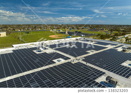 Aerial view of blue photovoltaic solar panels mounted on industrial building roof for producing green ecological electricity. Production of sustainable energy concept 138323203