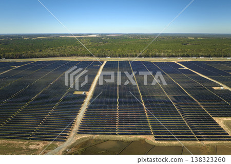 Aerial view of big sustainable electric power plant with many rows of solar photovoltaic panels for producing clean electrical energy. Renewable electricity with zero emission concept Aerial view of big sustainable electric power plant with many rows of solar photovoltaic panels for producing clean electrical energy. Renewable electricity with zero emission concept 138323260