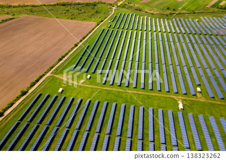 Aerial view of big sustainable electric power plant with many rows of solar photovoltaic panels for producing clean ecological electrical energy. Renewable electricity with zero emission concept. Aerial view of big sustainable electric power plant with many rows of solar photovoltaic panels for producing clean ecological electrical energy. Renewable electricity with zero emission concept. 138323262
