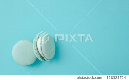 Pair of turquoise macarons on solid turquoise background, teal monochrome food photography for summer concept Pair of turquoise macarons on solid turquoise background, teal monochrome food photography for summer concept 138323714