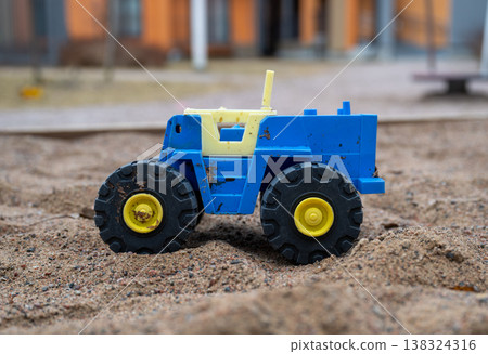 Toy construction truck in sandbox playground close up childhood play concept Toy construction truck in sandbox playground close up childhood play concept 138324316