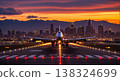 Large Passenger Airplane on Runway Against Sunset City Skyline 138324699