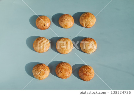 Golden Brown Cookies Arranged in a Grid on Blue Background Golden Brown Cookies Arranged in a Grid on Blue Background 138324726