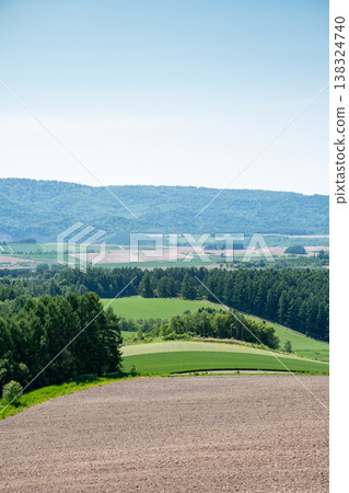 A landscape of rolling hills with fields of soil and fields of greenery. A landscape of rolling hills with fields of soil and fields of greenery. 138324740
