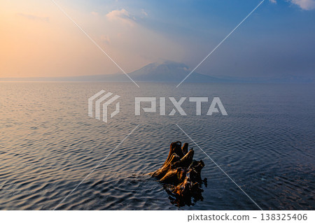 Lake Shikotsu bathed in the morning light; a striking natural landscape of Hokkaido with driftwood. Lake Shikotsu bathed in the morning light; a striking natural landscape of Hokkaido with driftwood. 138325406