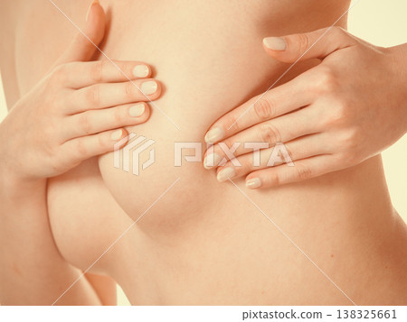 Woman examining her breasts for breast cancer Woman examining her breasts for breast cancer 138325661