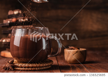 Hot chocolate in glass mug on wooden table Hot chocolate in glass mug on wooden table 138325695