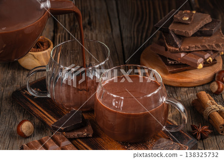 Pouring hot chocolate into glass cups 138325732