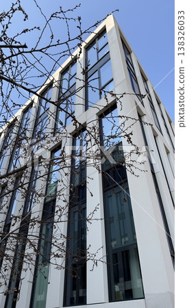 Modern building framed by tree branches in Prague on a clear day during autumn Modern building framed by tree branches in Prague on a clear day during autumn 138326033
