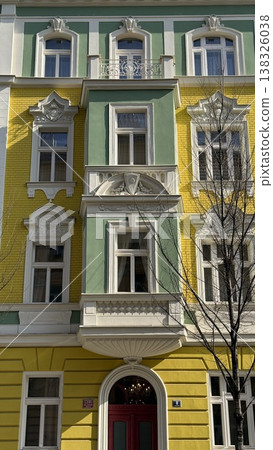 Colorful building in Prague with yellow and green facade standing on a sunny day in a quiet street 138326038