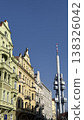 Modern television tower stands tall beside historic buildings in Prague under clear blue sky during daytime hours 138326042
