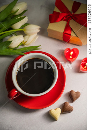 Valentine's Day festive red background. Cake with red heart, cup of coffee, gift box and tulip flower Valentine's Day festive red background. Cake with red heart, cup of coffee, gift box and tulip flower 138326696