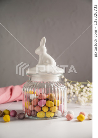Easter holiday Spring background with jar full of mini eggs candies over bright background Easter holiday Spring background with jar full of mini eggs candies over bright background 138326732