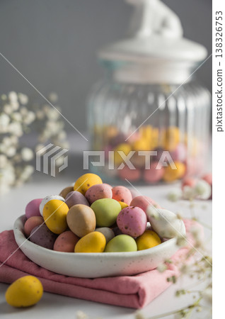 Easter holiday Spring background.Mini chocolate eggs candies in a plate over bright background, copy space Easter holiday Spring background.Mini chocolate eggs candies in a plate over bright background, copy space 138326753