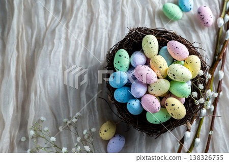 Easter mini decorative eegs in a nest with willow twigs, bright background Easter mini decorative eegs in a nest with willow twigs, bright background 138326755