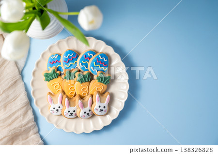 Easter spring holiday background with easter cookies in a plate: bunny, carrot and egg with white tulips in a vase Easter spring holiday background with easter cookies in a plate: bunny, carrot and egg with white tulips in a vase 138326828