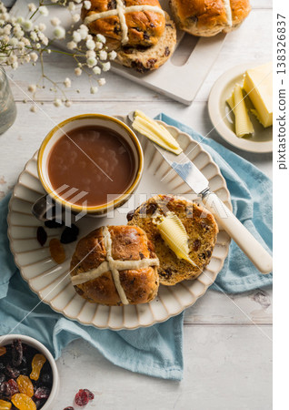Easter food table setting. Cross Buns with butter, served with tea. Breakfast concept Easter food table setting. Cross Buns with butter, served with tea. Breakfast concept 138326837