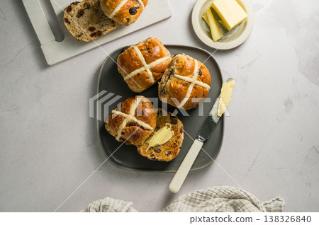 Cross Buns with butter in a plate. Breakfast concept. Top view. Easter treat buns Cross Buns with butter in a plate. Breakfast concept. Top view. Easter treat buns 138326840